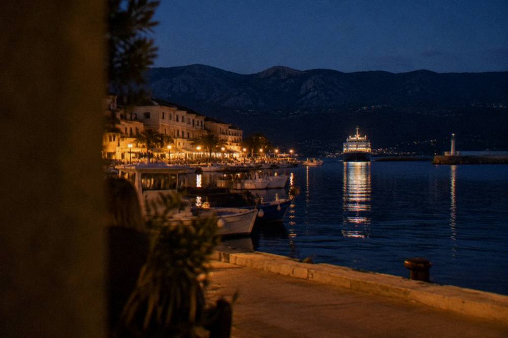 A ferry approaching a Corsican harbour town at dusk