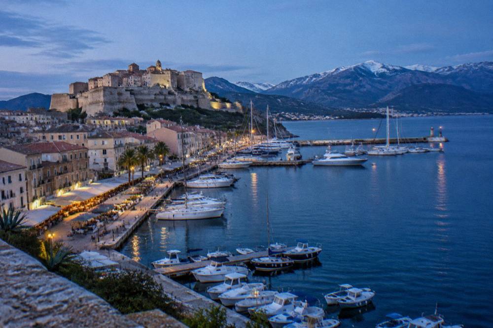 Harbour town on the Corsican coast with boats and hills behind