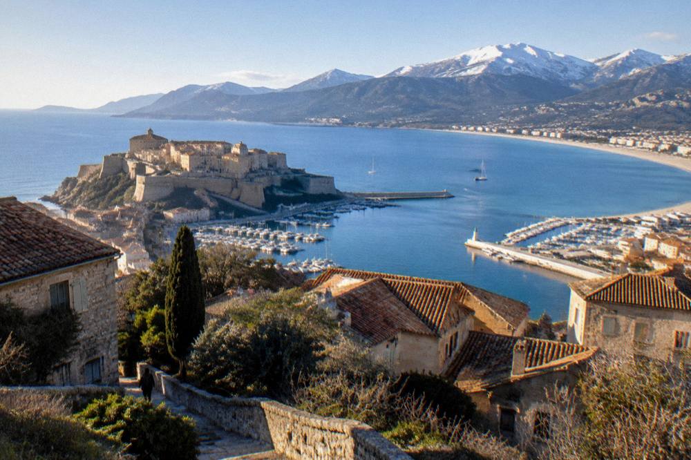 View over a Corsican hilltop village toward the sea in the distance