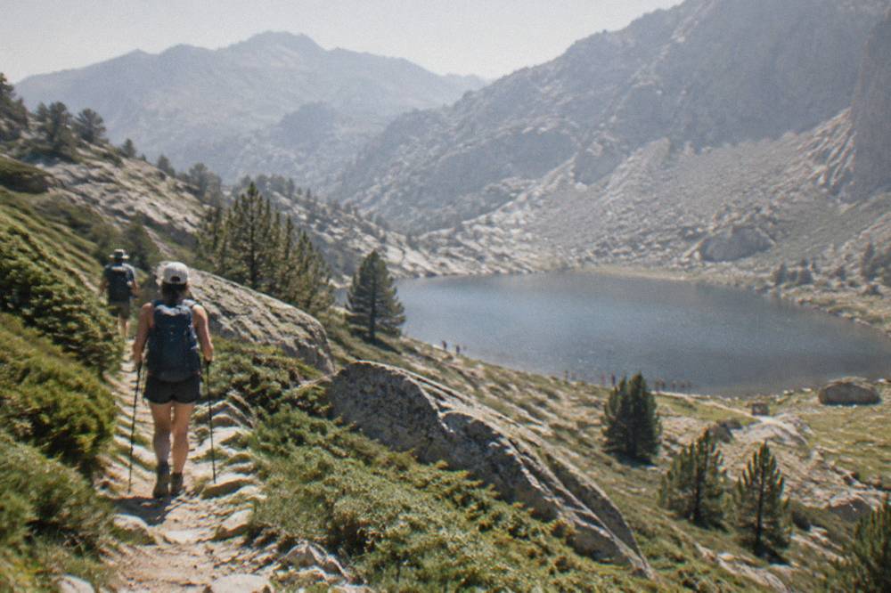 Hikers on a mountain trail among granite peaks in the Corsican interior