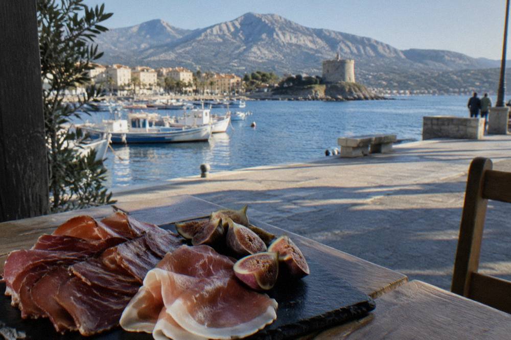 Sliced Corsican prisuttu ham and lonzu arranged on a slate plate with figs