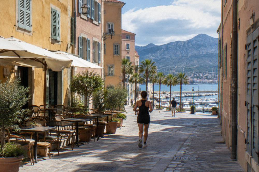 An old town street in Ajaccio with shuttered facades and café tables