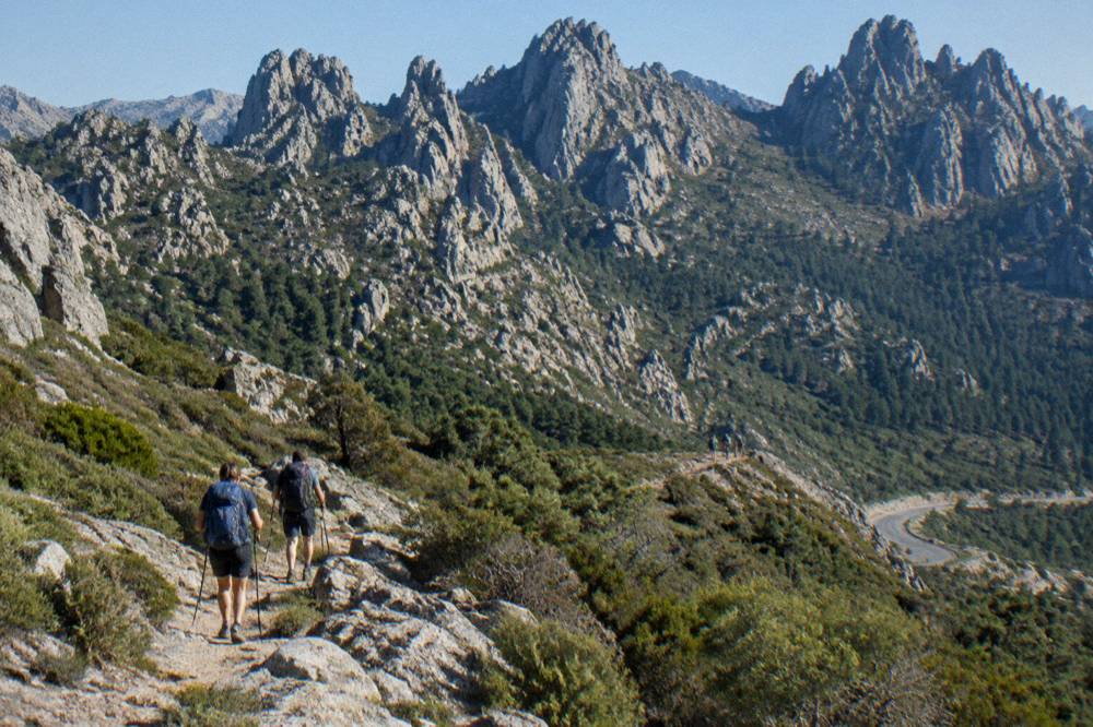 Hikers with backpacks on a rocky mountain path high in the Corsican interior