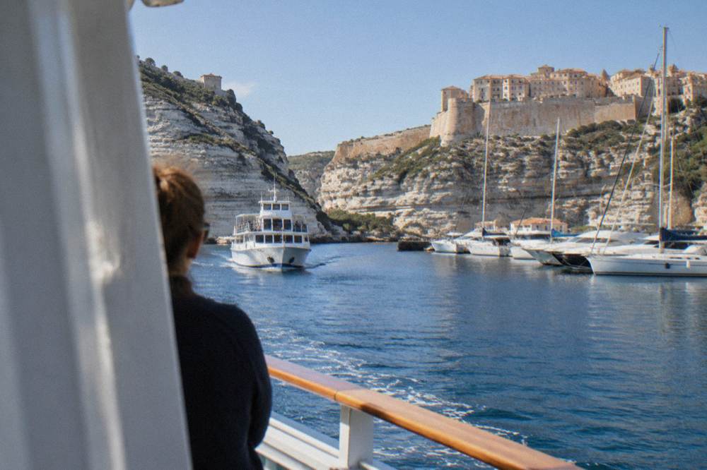 A ferry approaching a Corsican harbour town in morning light