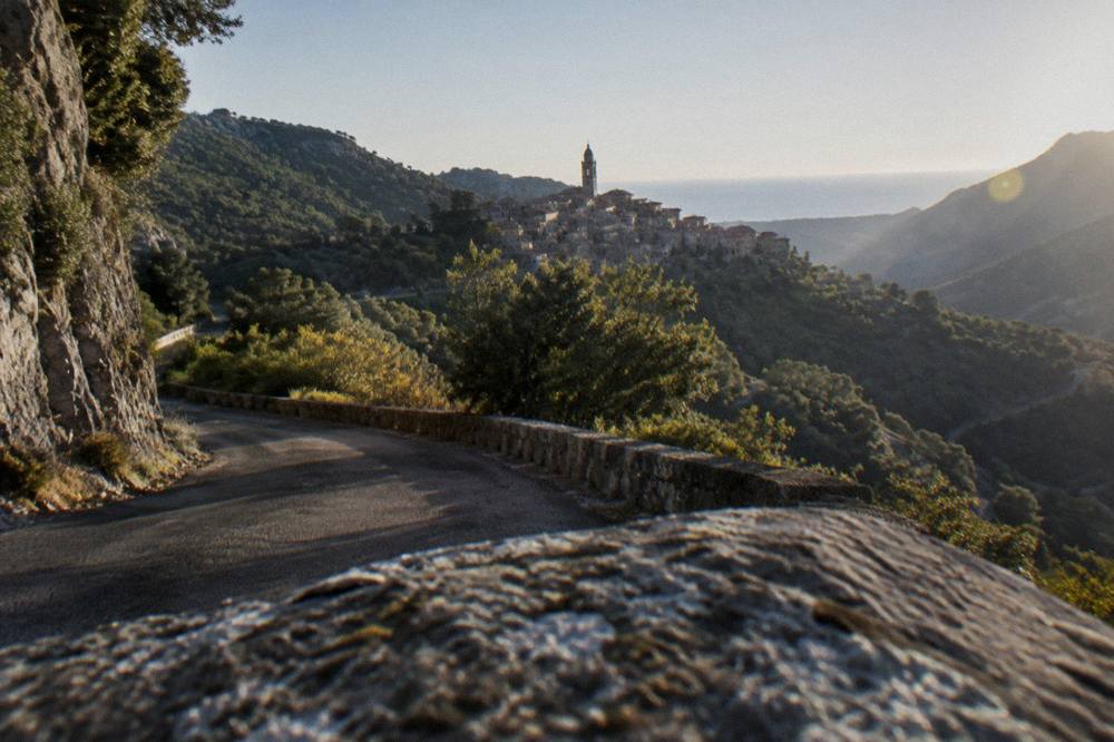 A narrow mountain road winding through Corsican maquis and rock