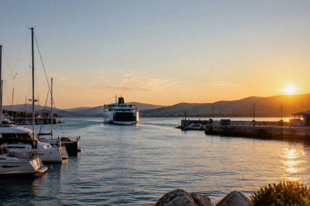 A ferry sailing into a Corsican harbour at golden hour
