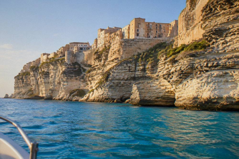 The white limestone cliffs of Bonifacio seen from a boat on clear blue water