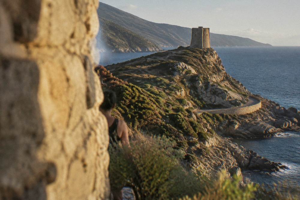 A stone watchtower on a headland above the sea in Cap Corse