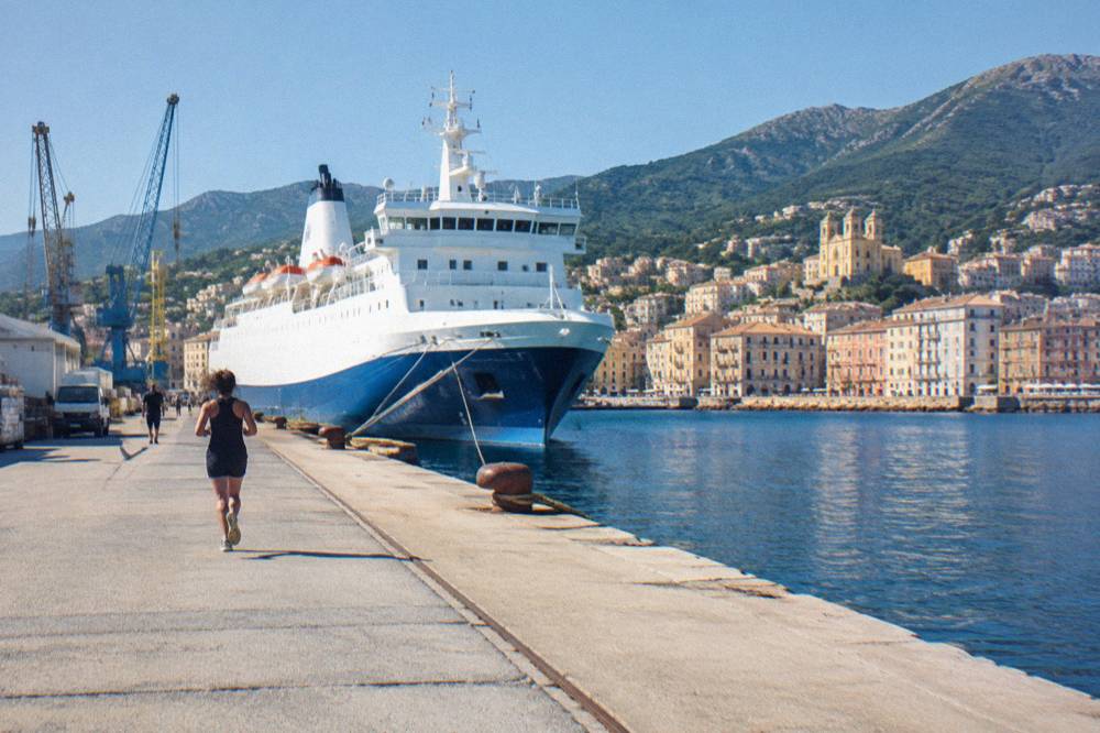 A ferry docked at the port of Bastia with the town behind it