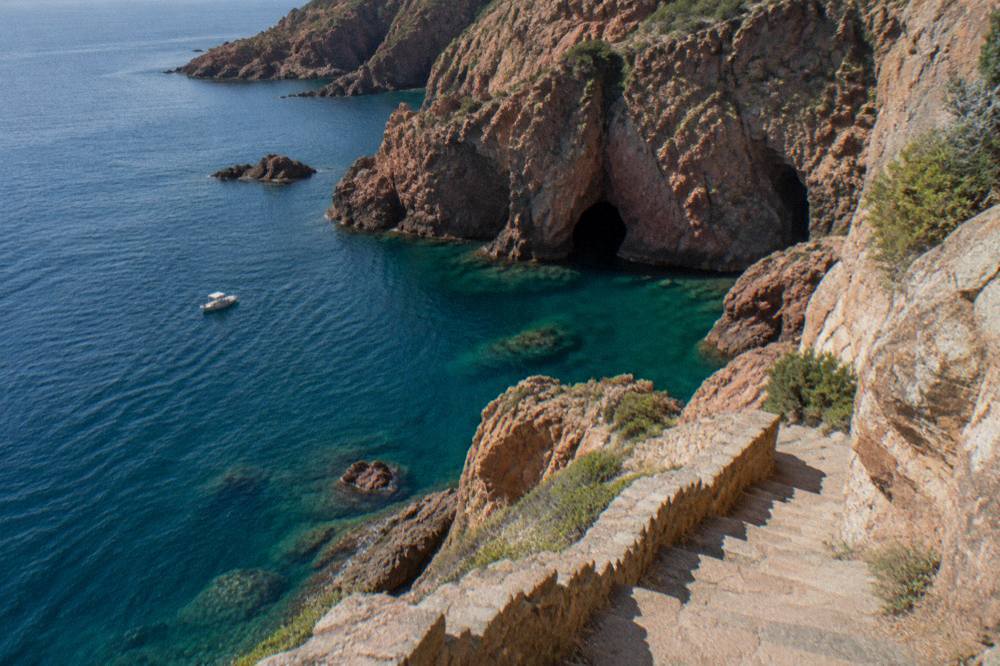 Stone steps carved into a cliff face descending towards clear sea at Bonifacio