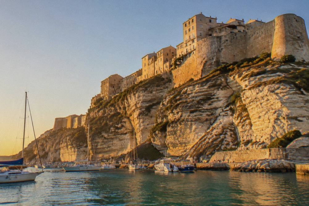 The Bonifacio citadel standing above the harbour entrance with boats moored below
