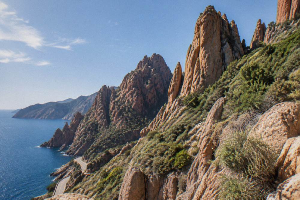 Red granite rock formations of the Calanques de Piana rising above the sea