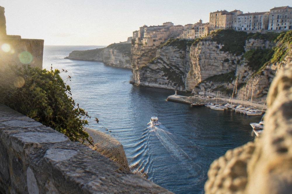 A small boat easing out of Bonifacio harbour toward the open strait