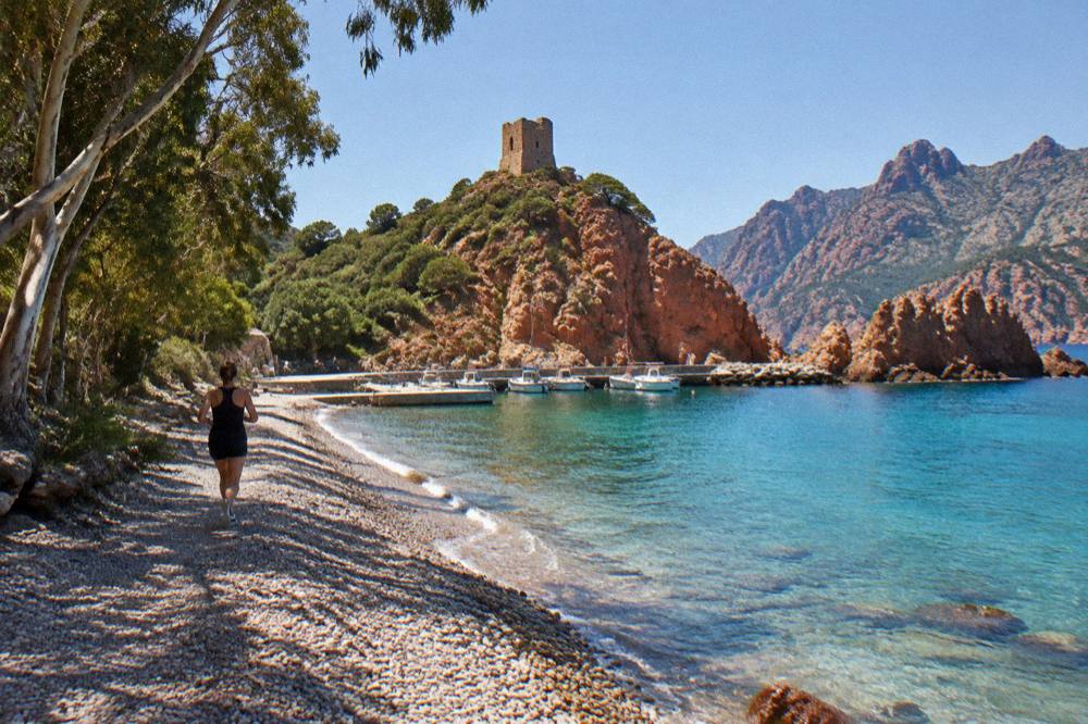 Turquoise water against red rock in a cove of the Gulf of Porto in Corsica