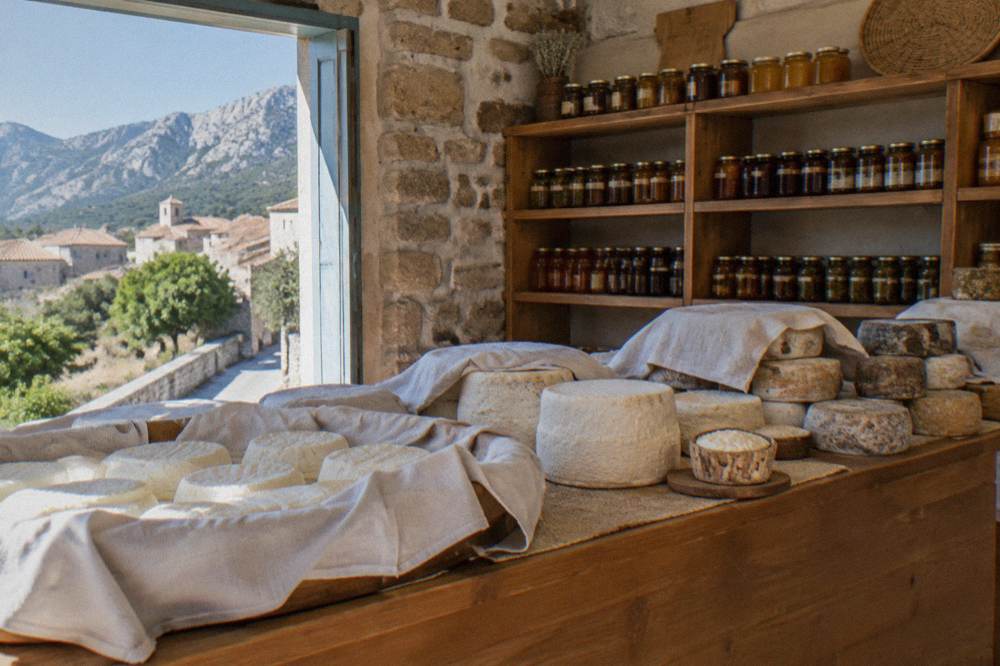 A tasting plate of Corsican honey jars, olive oil bottles and small pastries on a shop counter